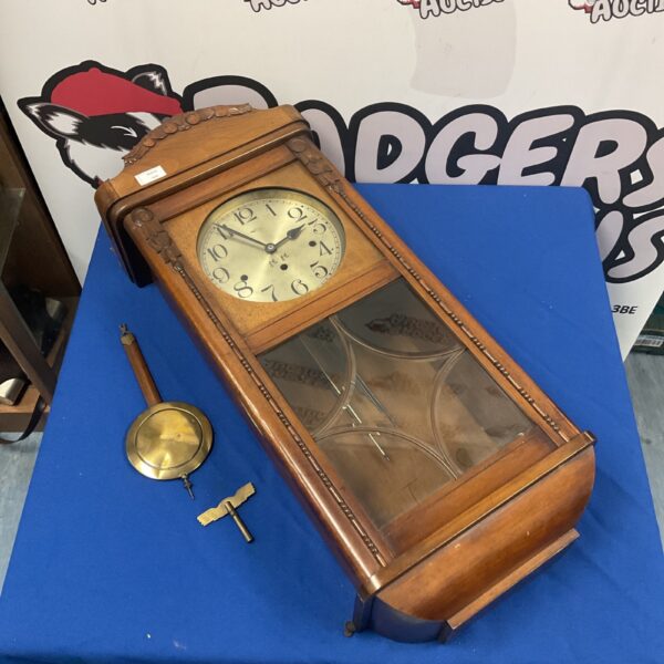 Vintage German wall clock with pendulum and key.
