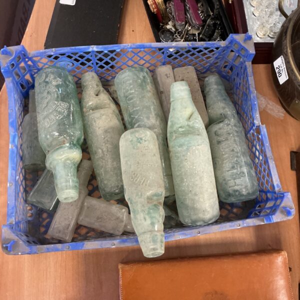 Tray of vintage green glass bottles for collectors.