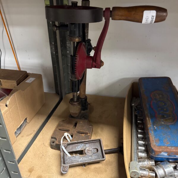 Vintage hand drill press with cast iron base and lever.