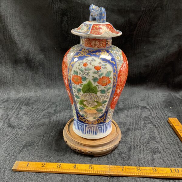 Vintage Japanese Imari porcelain vase with wooden base.