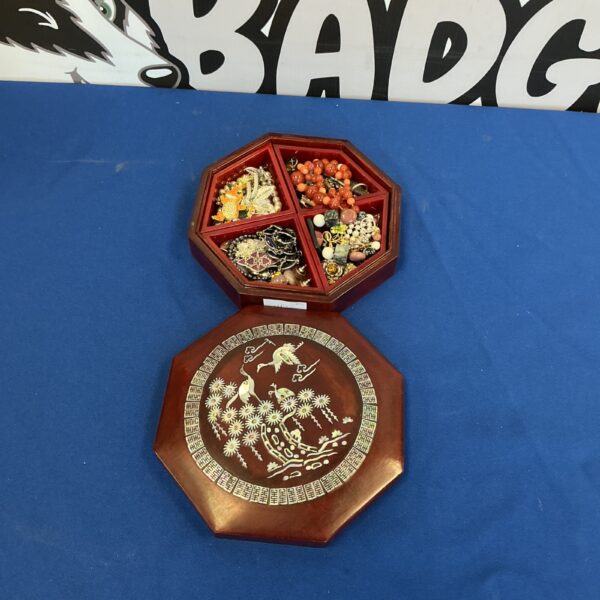 Vintage jewellery box with assorted beaded necklaces and bracelets inside.