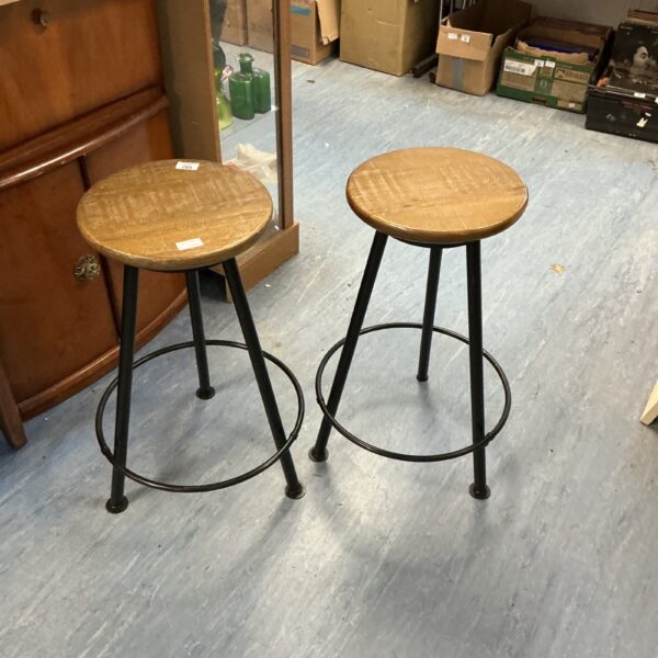 Pair of vintage lab stools with metal legs and wooden seats.