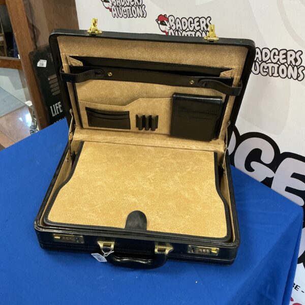 Open vintage leather briefcase with interior compartments.