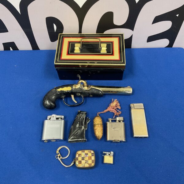 Vintage lighters and musical keyring inside a cash tin.
