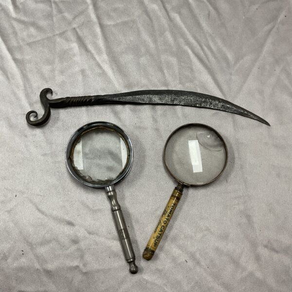 Vintage magnifying glasses and letter opener set on display.