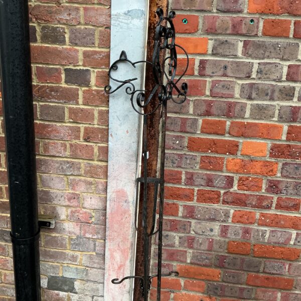 Three vintage metal bird feeder poles with scrolled detailing.