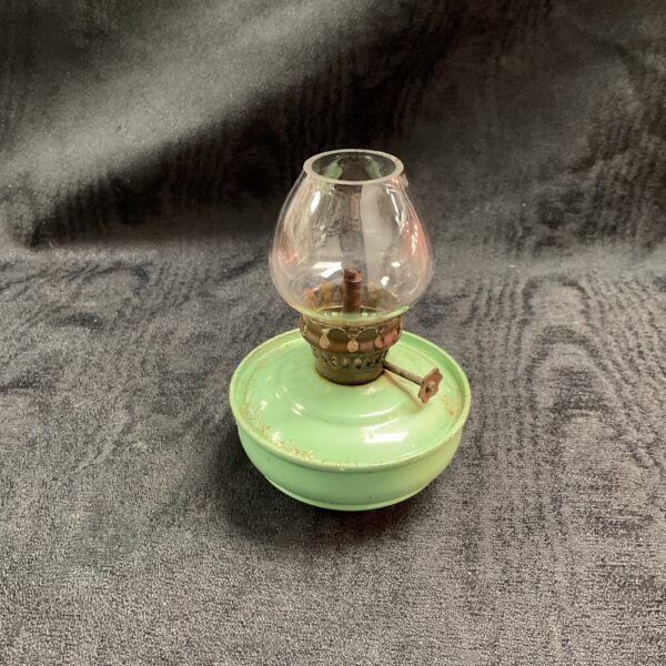 Small vintage green oil lamp with clear glass shade.