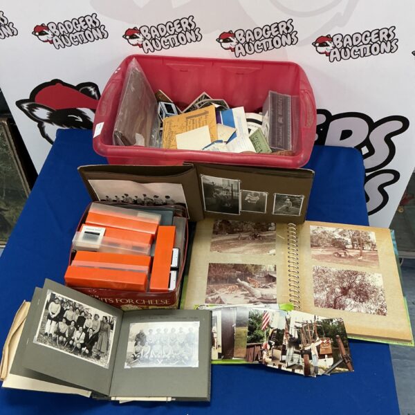 Large collection of vintage photographs and 35mm slides in a red bin.