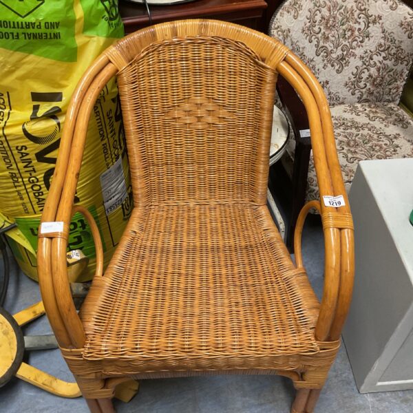 Vintage brown rattan armchair with woven seat and back.