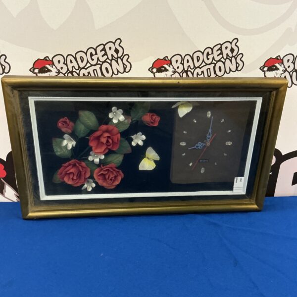 Vintage rose wall clock with detailed floral design.