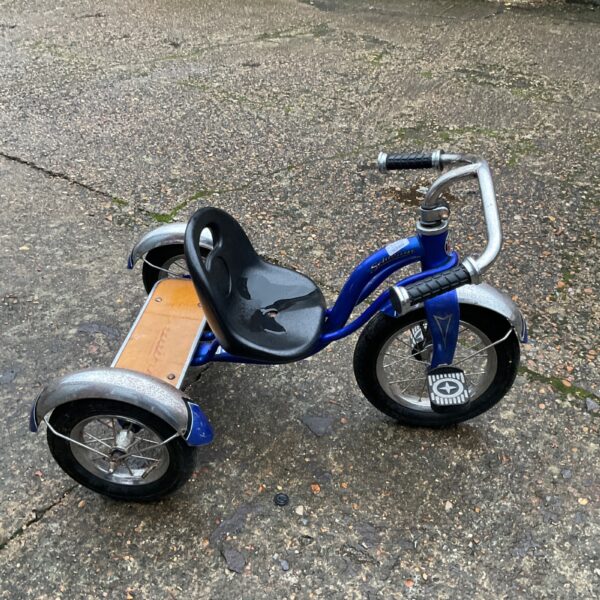Vintage blue Schwinn childs trike with wooden seat.