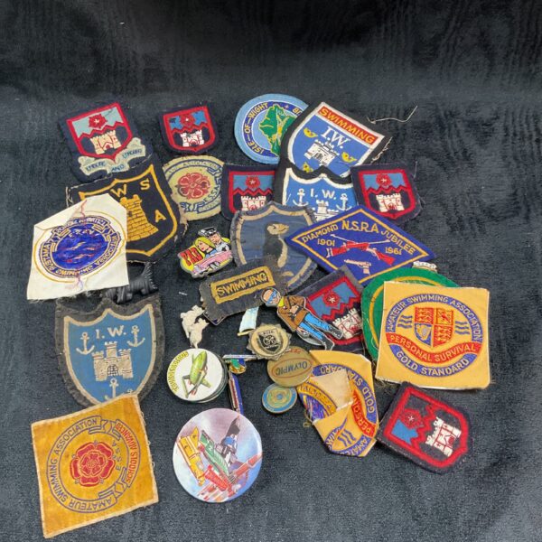 Vintage collection of cloth and metal scout badges and emblems.
