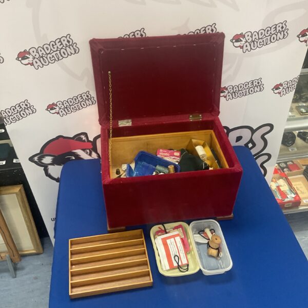 Red velvet vintage sewing chest with sewing supplies inside.