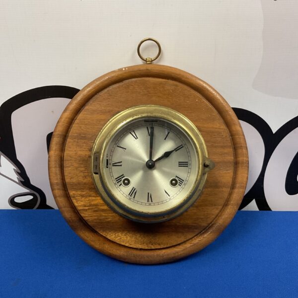Vintage brass ships bulkhead clock with white dial.