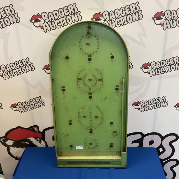 Front view of a vintage shove halfpenny board with coin holes.