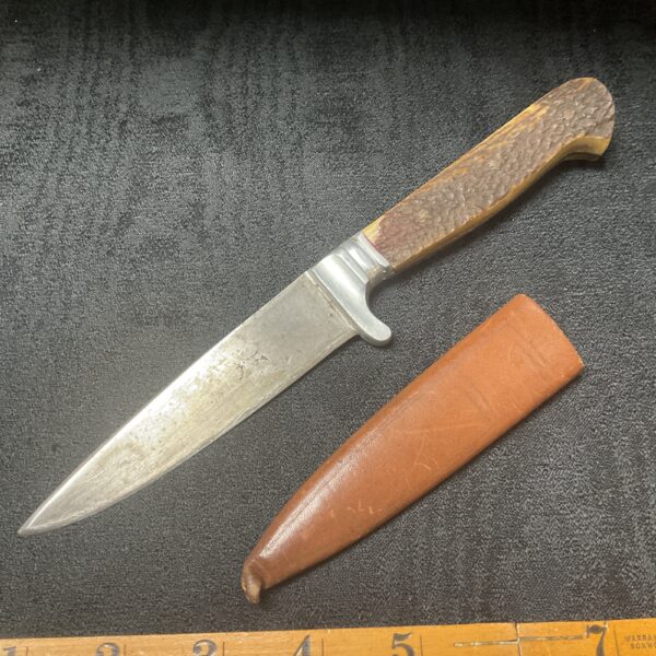 Vintage stag horn knife with leather sheath for hunting or collecting.