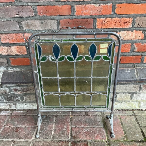 Vintage stained glass fire guard with copper frame and floral design.