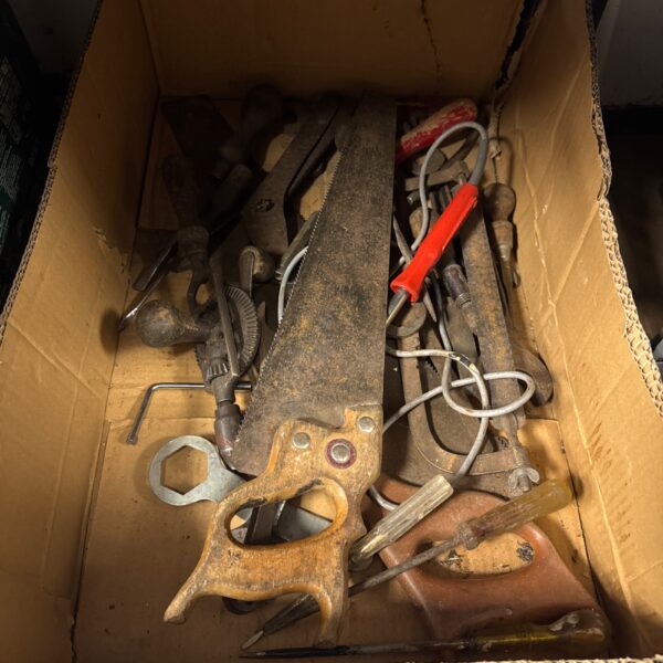 Vintage tool lot featuring antique saws and hand tools.