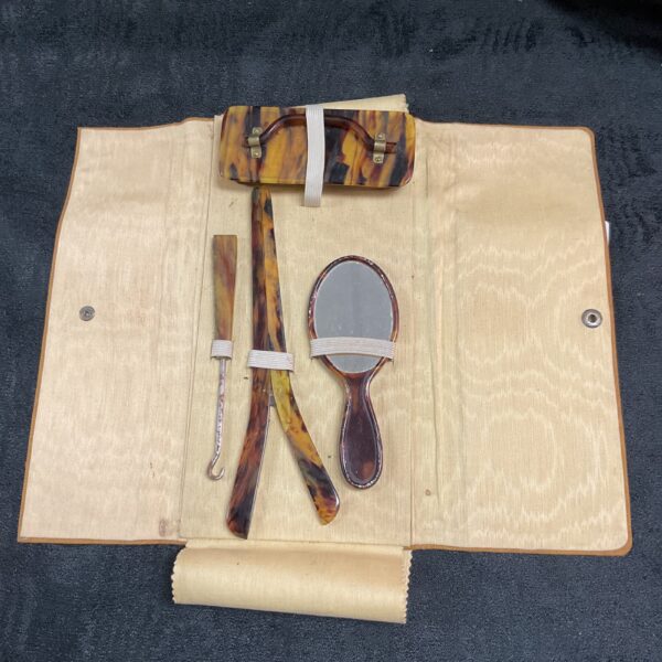 Vintage tortoise shell travel grooming set with mirror and boot hook.