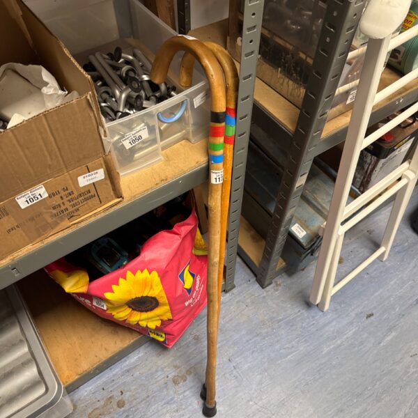 Pair of vintage wooden walking sticks with curved and straight handles.