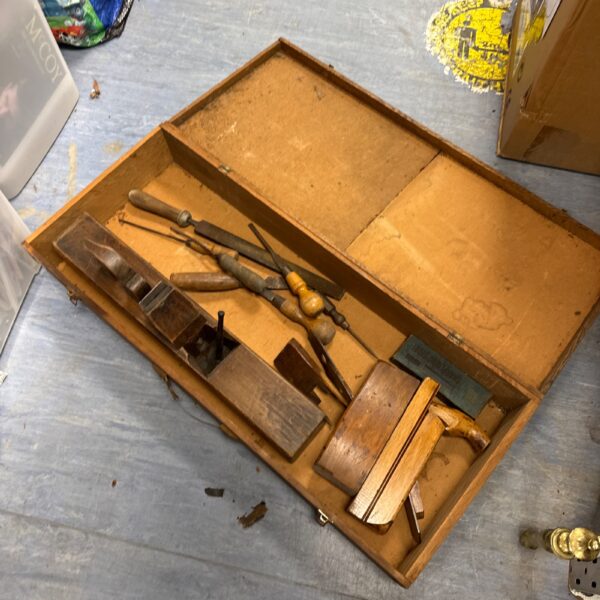 Vintage wooden tool box filled with antique tools and implements.