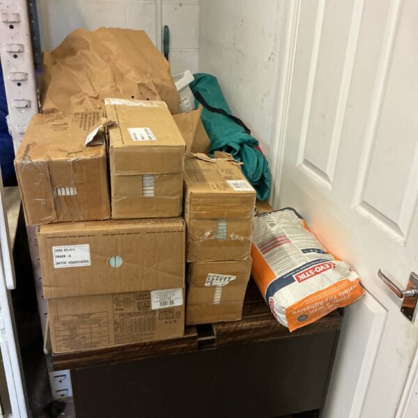 Stack of wall tiles and adhesive boxes for tiling projects.