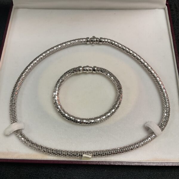 Elegant white gold bracelet and necklace set on display.