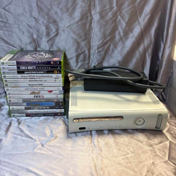 White Xbox 360 console with games, presented as seen in the photographs.