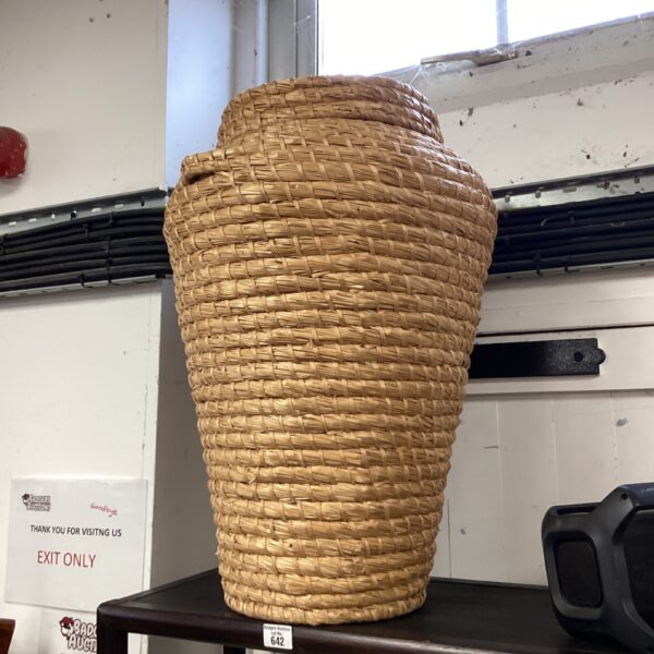 Tall wicker wash basket for laundry and storage.