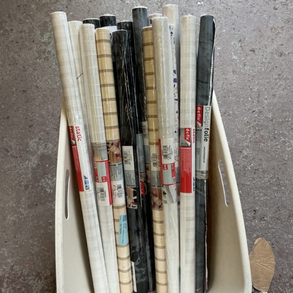 Multiple rolls of window privacy film in a plastic container.