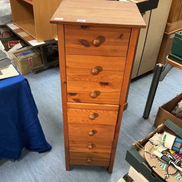 Tall wooden 7-drawer unit for bedroom storage.