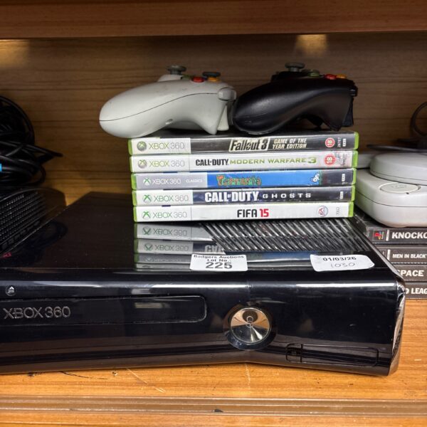 Xbox 360 console with controllers and games displayed.