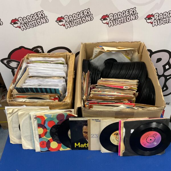 Vintage 7 inch vinyl records in a cardboard box.