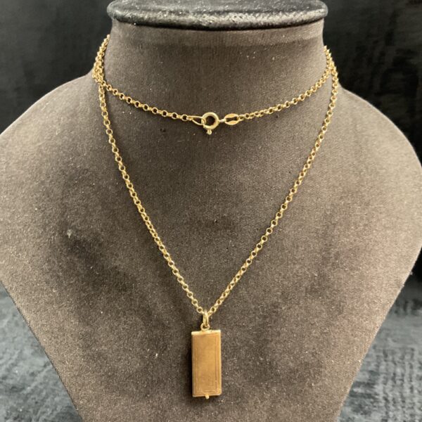 Close-up of 9ct gold London Bank Ltd cheque book pendant on necklace.