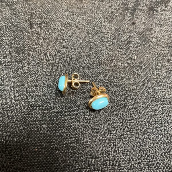 Close-up of 9ct gold turquoise stud earrings with hallmarked 375 pin.