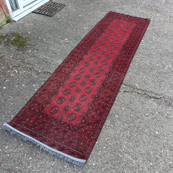 Red Afghan runner rug with geometric patterns, full view.