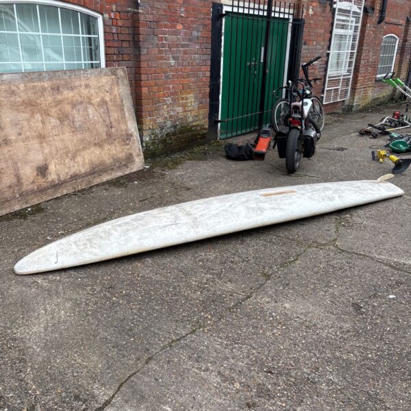 Vintage Alpha Phantom windsurfing board on cracked pavement.