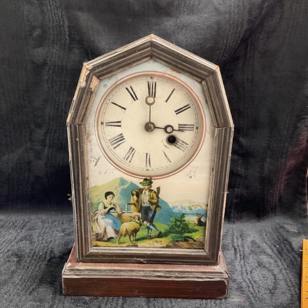 Antique Austrian mantle clock with painted glass door and pastoral scene.