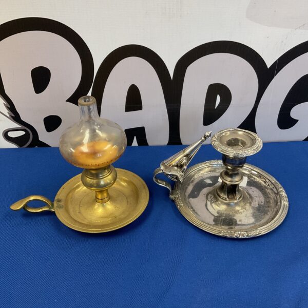 Antique brass chamber stick with scrolling arm and drip pan.
