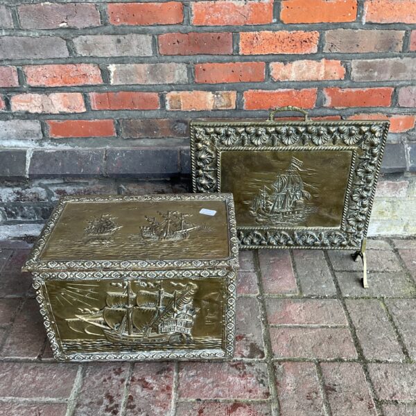 Antique brass log box with nautical sailing ship design.