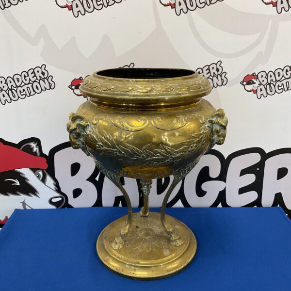Ornate antique brass planter with rams head handles.
