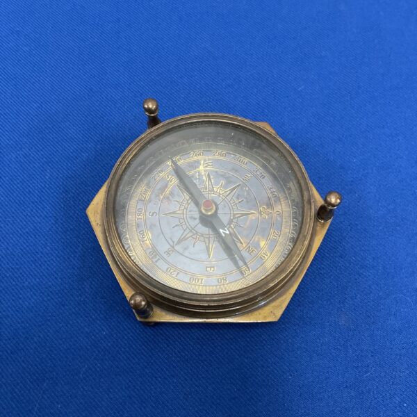 Antique brass compass with 40-year calendar, detailed view.