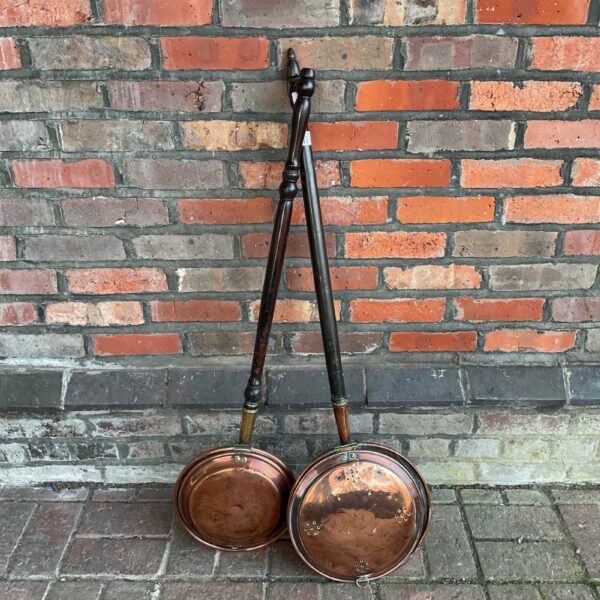 Pair of antique copper bed pans with wooden handles.