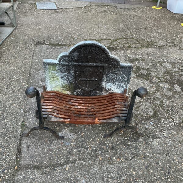 Antique Victorian fireplace grate with ornate fire dogs.