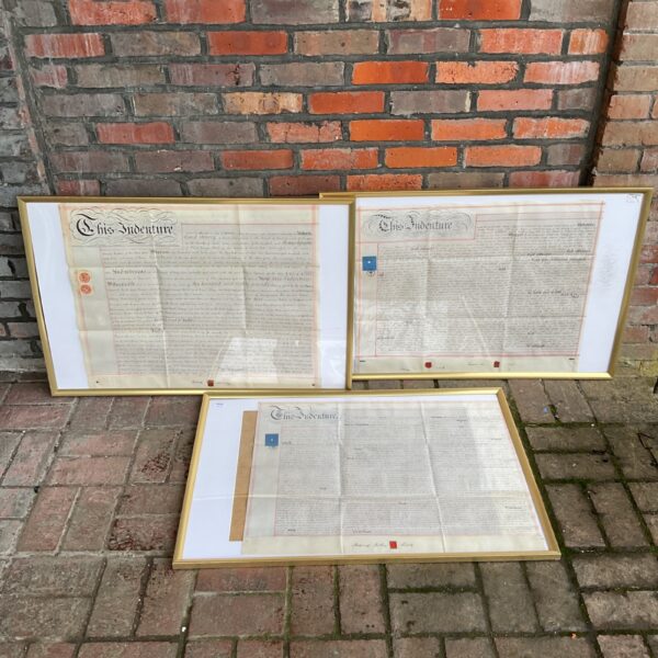 Framed antique indentures with wax seals, vintage legal documents.