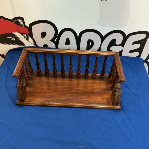 Antique mahogany book rack with carved details for displaying books.