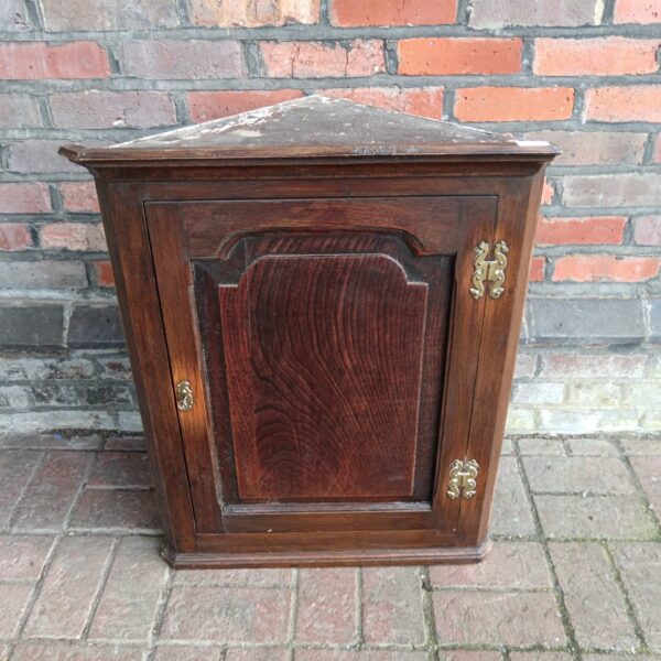 Antique oak corner cabinet with a single door.