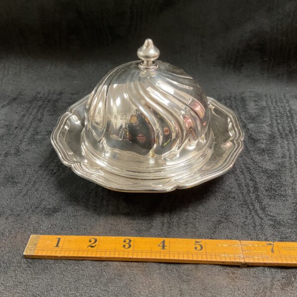 Antique silver butter dish with domed lid and swirl pattern.