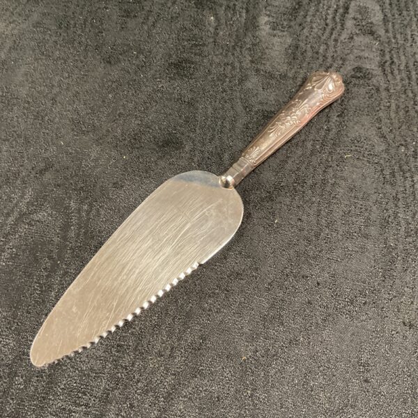 Antique silver pie server with hallmarked handle and serrated blade.