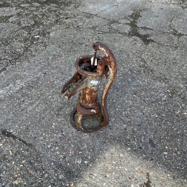 Antique cast iron water pump ornament for garden display.